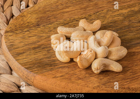 A handful of cashew nuts on a mango wood board. A healthy snack. Stock Photo