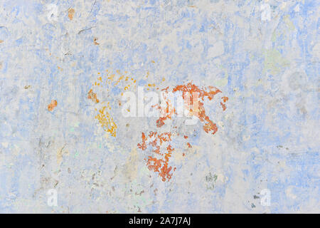 The wall with the remnants of plaster and old paint bluish and brown shades on gray concrete. Background. Stock Photo