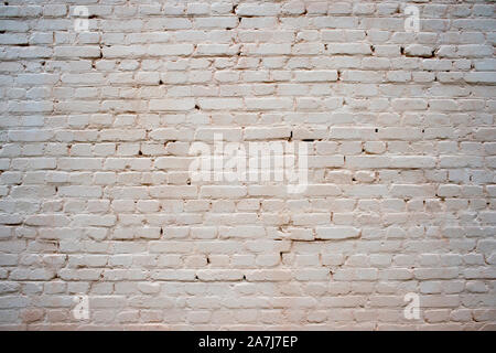 White painted brick wall with beige shade of color and volumetric shadows. Textured background. Stock Photo