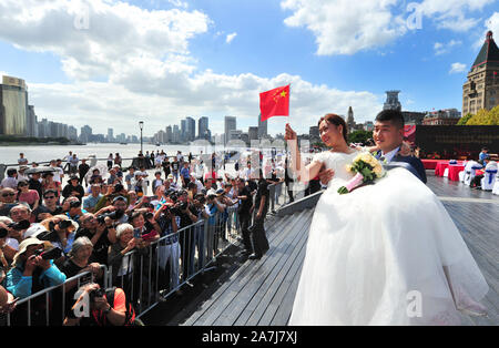People take pictures of a newly-wed by the Huangpu river in Shanghai, China, 19 September 2019.   15 couples held group weddings by the Huangpu river Stock Photo