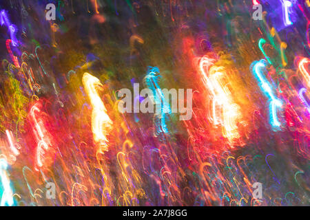 Abstract glowing background of multicolored chaotic neon rays as christmas candy canes on dark. Photographic effect with long exposure while motion. T Stock Photo