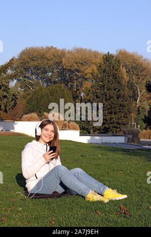 happy teenage girl listens to music from her smartphone Stock Photo