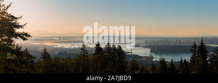 A sunrise view of downtown Vancouver, Stanley Park, and the Lions Gate Bridge as seen from Cypress Mountain. Stock Photo