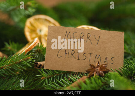 merry christmas card on spruce twigs with decorationscard on spruce twigs with decorations, shallow focus Stock Photo