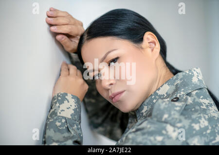 Dark-eyed Asian servicewoman feeling stressed and depressed Stock Photo