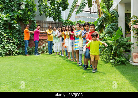 Group-of Happy Multi-generation Family walking Together in-train formation in-park of-their House Stock Photo