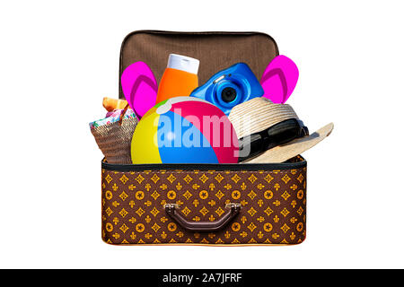 Packed vintage suitcase full of items for summer holidays travel, vacation, travel and trip isolated on white Stock Photo