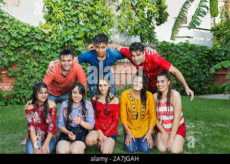 Group-Of Adult Male And Female Friends Having Fun Enjoy in The-Rain in-courtyard Of their House Stock Photo