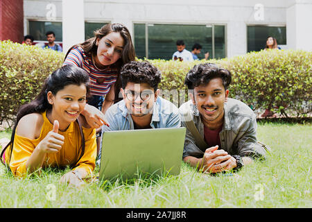 College Boys And Girls Students Classmates Together Showing Thumbs-up With laptop Chatting At-Campus Stock Photo