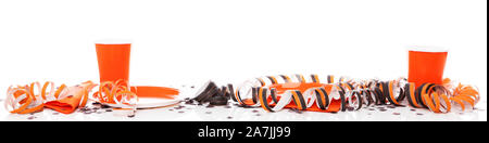 banner with halloween party decoration in orange and black, with paper plates and cups. in front of white background Stock Photo