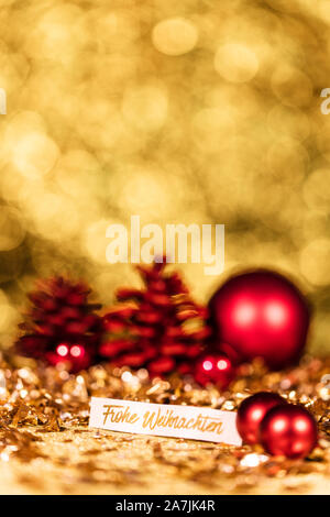 shiny gold and red christmas decoration and german text which means merry christmas Stock Photo