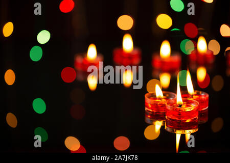 Indian Diwali Festival of-Lights focus on-foreground of-many burning tealight candles Stock Photo