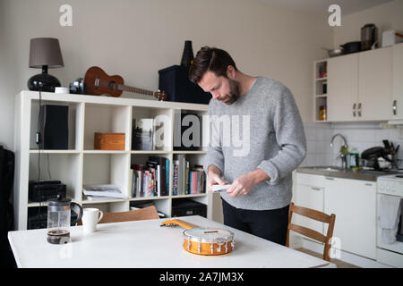 man replacing strings on banjo ukulele Stock Photo