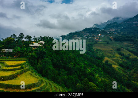 Top aerial birdseye view of harvested green rice terraces and small shacks in Sapa, North Vietnam. Shot in Autumn, October 2019 Stock Photo