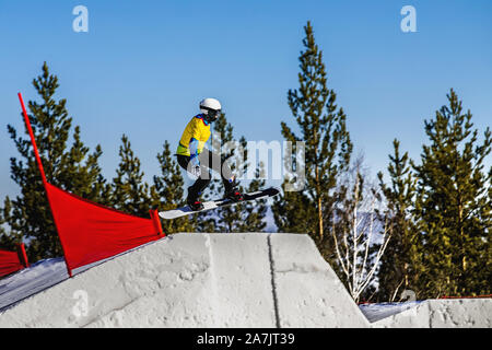 french woman snowboarder take a jump in snowboard cross competition Stock Photo