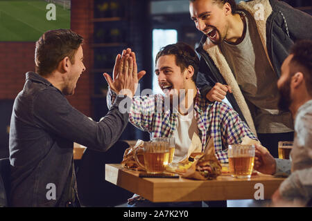 Friends talk, drink beer in a bar. Stock Photo
