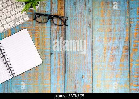 Minimalist flat lay composition of book, plant and glasses on the wooden table top view Stock Photo