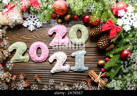 Colorful stitched digits 2020 2021 of polkadot fabric with Christmas decorations flat lay on wooden background Stock Photo