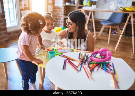 Young beautiful teacher and toddlers playing at kindergarten Stock Photo