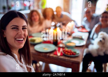 Family and friends dining at home celebrating christmas eve with traditional food and decoration, taking a selfie picture together Stock Photo