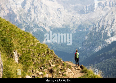 Italy dolomites lonely hiker in front of massive mountain rocks view marmolada Stock Photo