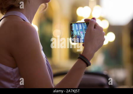 Cropped shot view of a woman's hands making video with mobile phone digital camera of baptism in church Stock Photo