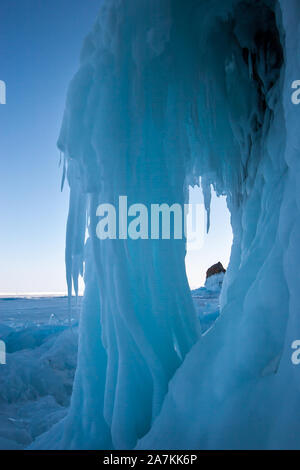 A large ice formation from icicles hanging from a cliff. Massive accumulation of ice. Twisted icicles forming a pillar. Stock Photo