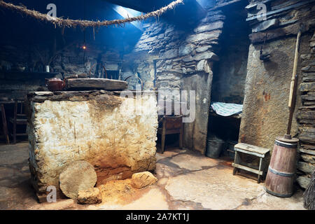 Interior of the Kirbuster Farm Museum, a firehoose, showing the central stone hearth, and stone neuk bed, Kirbuster, Mainland, Orkney, Scotland Stock Photo