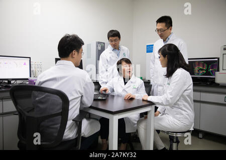 (191103) -- SHANGHAI, Nov. 3, 2019 (Xinhua) -- Geng Meiyu (C), key inventor of the drug GV-971, also a researcher of Shanghai Institute of Materia Medica under Chinese Academy of Sciences, discusses the research progress with her team at the Green Valley institute in Shanghai, east China, Nov. 3, 2019. A home-grown drug for treating Alzheimer's disease has been approved by the National Medical Products Administration to hit the market, according to its developers Saturday. The drug, GV-971, was developed by Ocean University of China, Shanghai Institute of Materia Medica under Chinese Academ Stock Photo