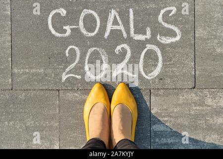 2020 goals, written on gray sidewalk with woman legs, top view Stock Photo