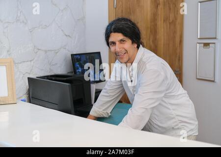 Portrait of handsome man working at the reception desk in resort hotel Stock Photo