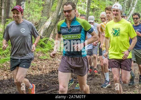 People running in a race along a wooded trail Stock Photo