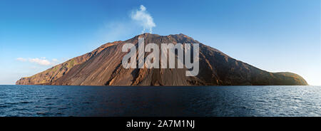 The stromboli vulcano erupting on the 'Sciara del Fuoco' north west side, day shot, blue sky background, panoramic shot, eolians islands, sicily, ital Stock Photo