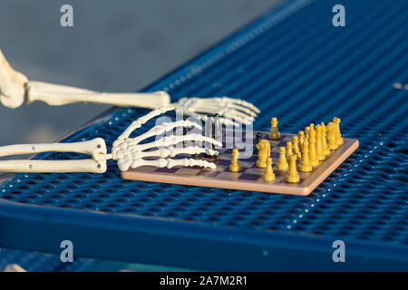 Skeleton making his move in chess Stock Photo