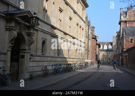 Cyclists in Trinity Lane, with students bikes outside a college, University of Cambridge, Cambridge, Cambs., England Stock Photo