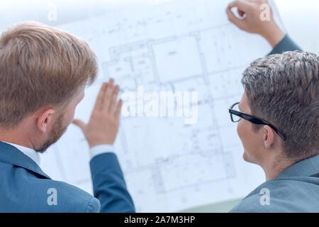architect discussing with the client a blueprint of the project. Stock Photo