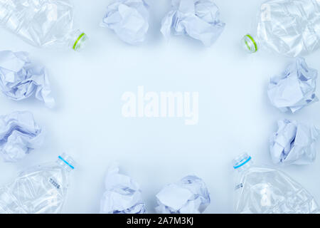 Recycling. The frame of used plastic bottle and crumpled paper on white background with copy space. Recycle and reuse concept