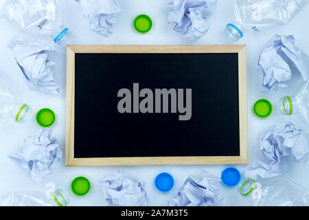 Recycling. The frame of used plastic bottle, blackboard and crumpled paper on white background with copy space. Recycle and reuse concept