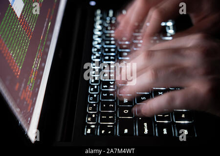 Moving hands typing on a computer keyboard - concept cybersecurity, phishing, hacking, social engineering attack, dark web, viruses and trojans Stock Photo