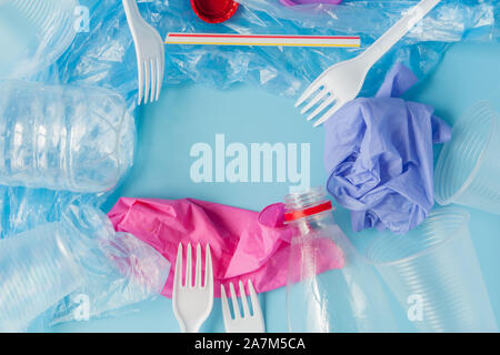 Top view of various kinds of disposable plastic waste on blue background, copy space. Stock Photo