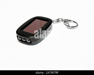 Flashlight keychain LED. Charging from the solar battery. Close-up. Isolated over white background. Stock Photo
