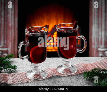 Mulled Wine Glasses On The Table In Front Of The Burning Fireplace