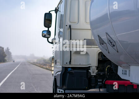 tank truck of dangerous goods on the road a foggy day Stock Photo