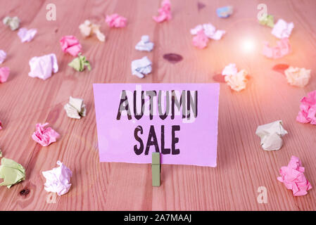 Writing note showing Autumn Sale. Business concept for having great discounts products on season after summer Colored crumpled papers wooden floor bac Stock Photo