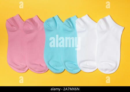 Set of short socks in white, pink, blue on a yellow background. Stock Photo