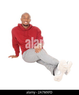A handsome African American man sitting in a burgundy hoody on the floor resting after exercise, isolated for white background Stock Photo