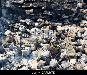 Beautiful red flame from slice wood, dark grey black coals inside metal brazier. Wood burning in the brazier on bright yellow flame. Flames fire prepa Stock Photo