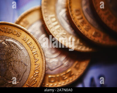 Closeup of Mexican coins (10 pesos) with  bank note as a background. Selective focus Stock Photo