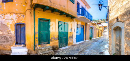 Narrow street with colorful stone houses in the old village of Pano Elounda, Crete, Greece.