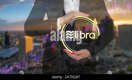 businesswoman presenting the Libra cryptocurrency logo on the background of modern architecture Stock Photo